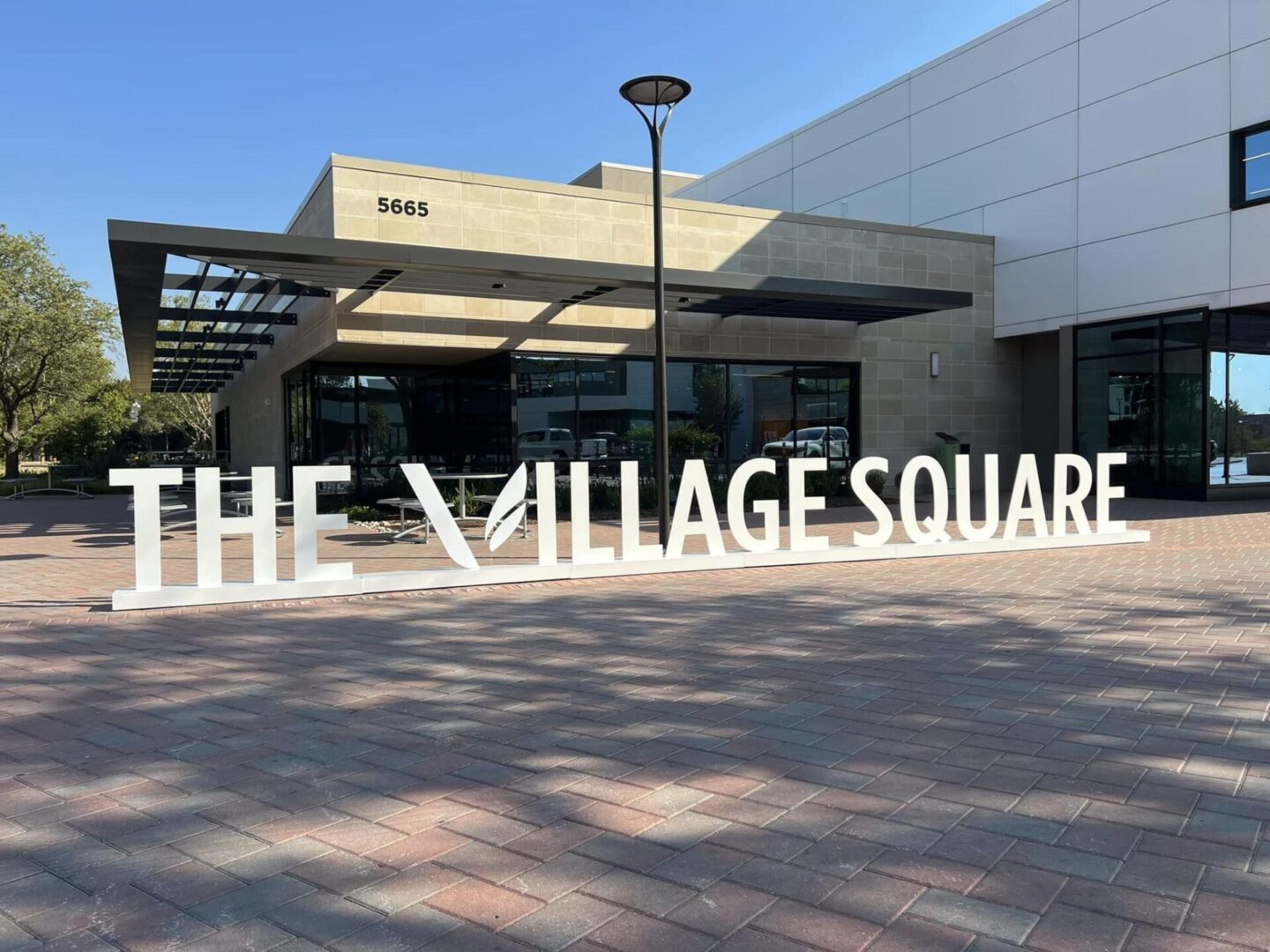 A large sign that says the village square.