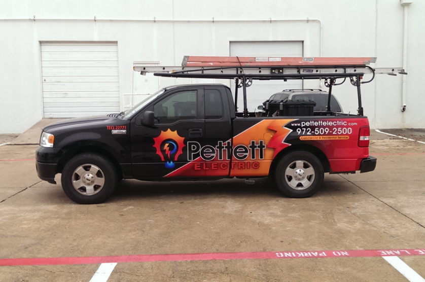 A black truck with orange and red lettering.