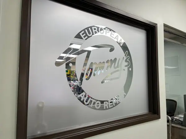 A mirror with the name tommy 's auto rental on it.