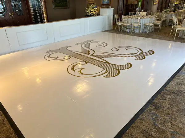 A large white dance floor with a monogram on it.