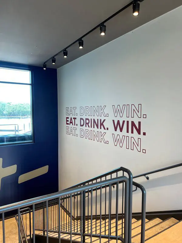 A wall with words written on it and a metal railing.