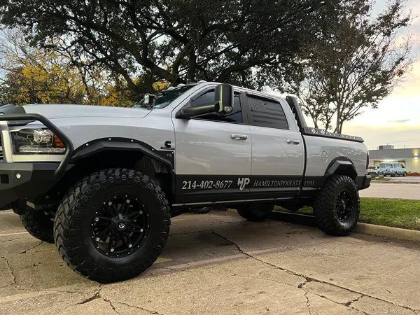 A white truck parked on the side of a road.