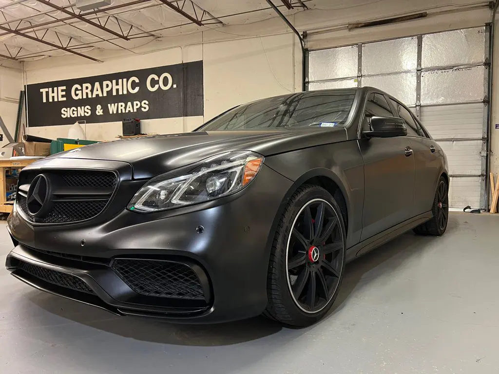 A black car parked in front of a building.